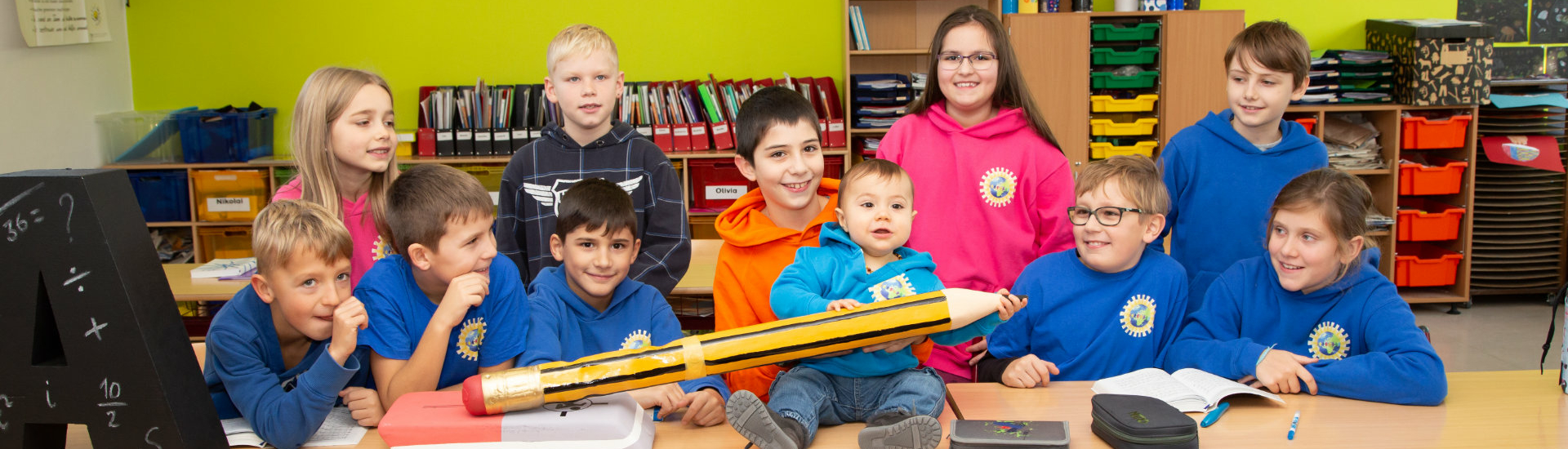 Gruppenbild mit mehreren Kindern verschiedenen Alters am Tisch